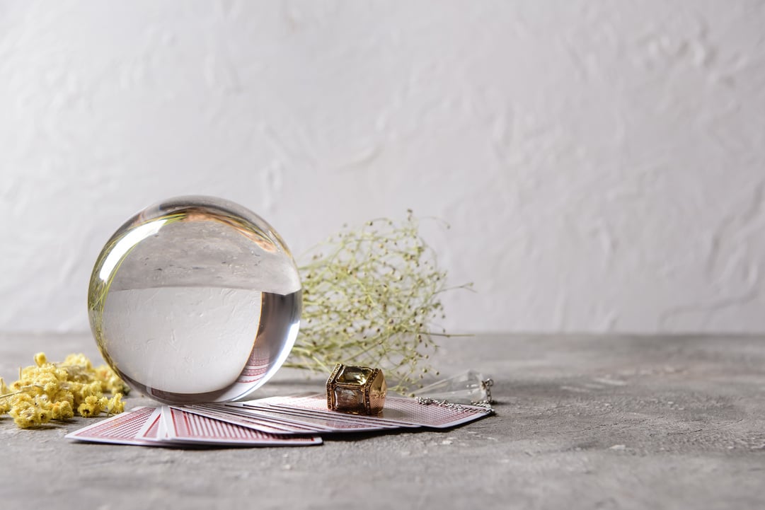 Crystal Ball of Fortune Teller, Cards and Dry Herbs on Table